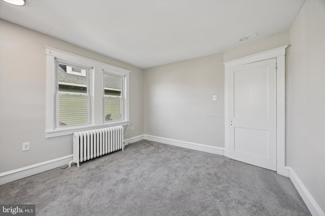 unfurnished room with radiator, carpet, and baseboards