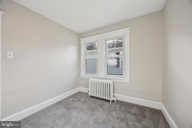 empty room with radiator, baseboards, and carpet floors