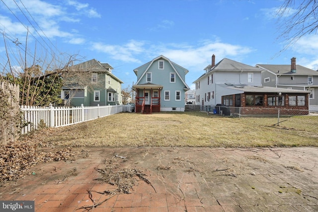 view of front of home featuring a fenced backyard, a front lawn, and a gambrel roof