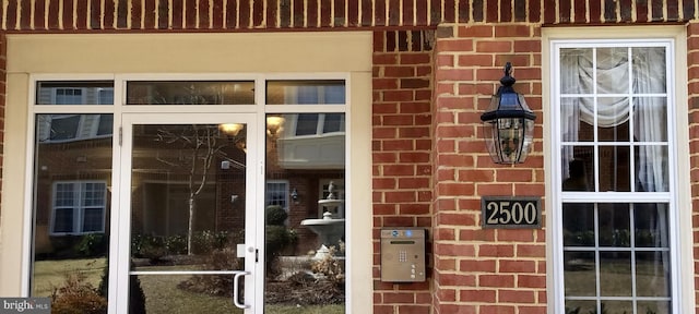 view of exterior entry featuring brick siding