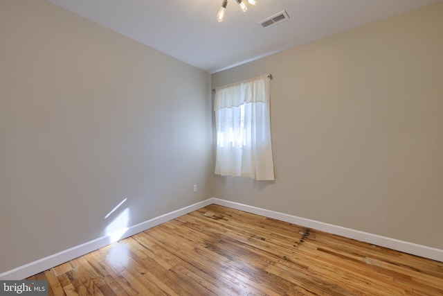 unfurnished room featuring baseboards, visible vents, and light wood finished floors