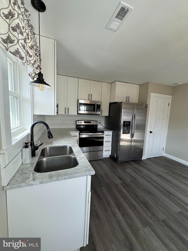 kitchen with white cabinetry, visible vents, appliances with stainless steel finishes, and a sink