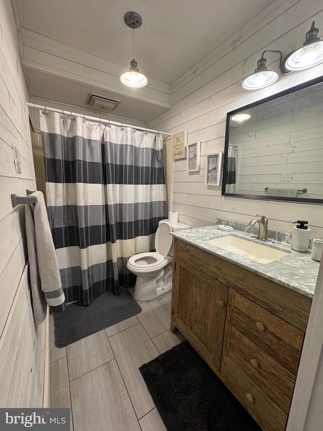 full bathroom with toilet, wooden walls, vanity, and a shower with curtain