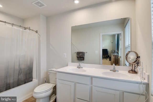 bathroom with visible vents, a sink, toilet, and double vanity