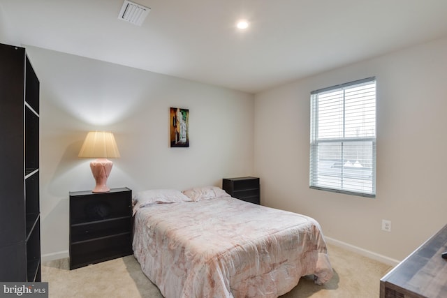 bedroom with light carpet, visible vents, and baseboards