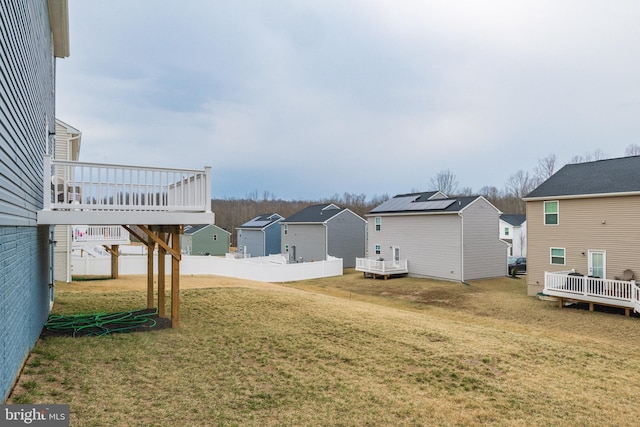 view of yard with a wooden deck, a residential view, and fence