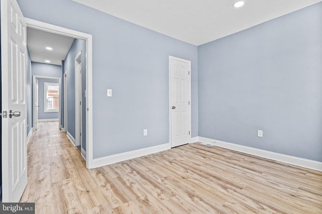 unfurnished room featuring recessed lighting, light wood-type flooring, and baseboards