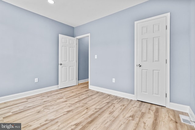 unfurnished bedroom featuring light wood-type flooring, visible vents, and baseboards