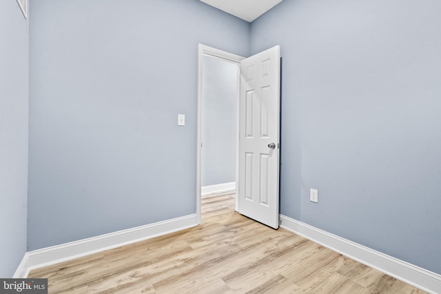 unfurnished room with light wood finished floors and baseboards