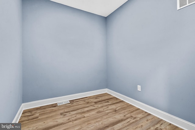 unfurnished room featuring visible vents, light wood-style flooring, and baseboards