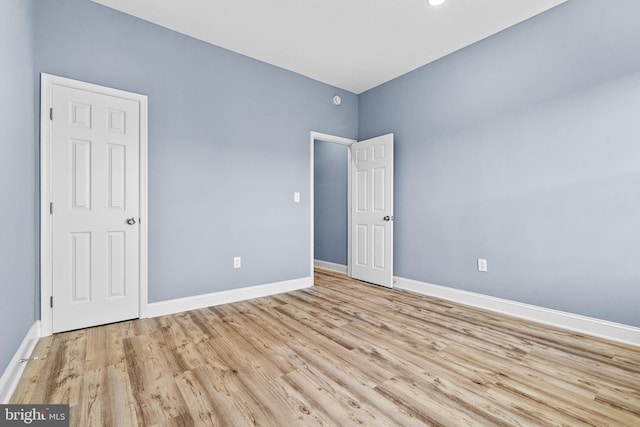 unfurnished bedroom featuring light wood-style flooring and baseboards