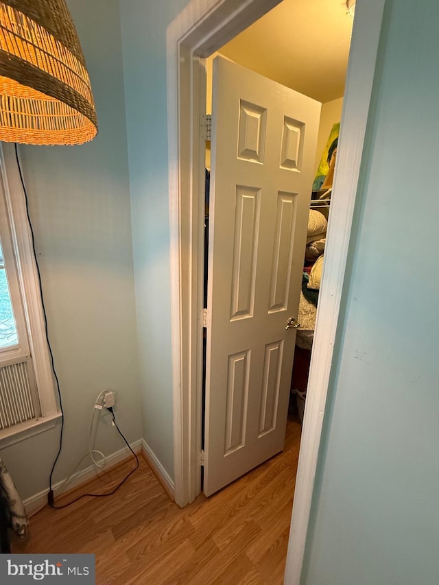 hallway featuring baseboards and light wood finished floors