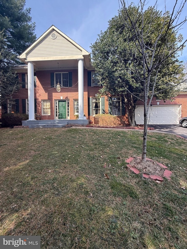 neoclassical / greek revival house with a front yard, a garage, and brick siding