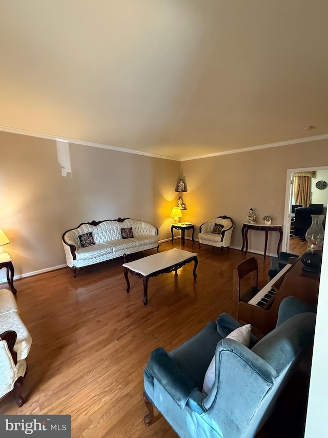 living room featuring baseboards, wood finished floors, and crown molding