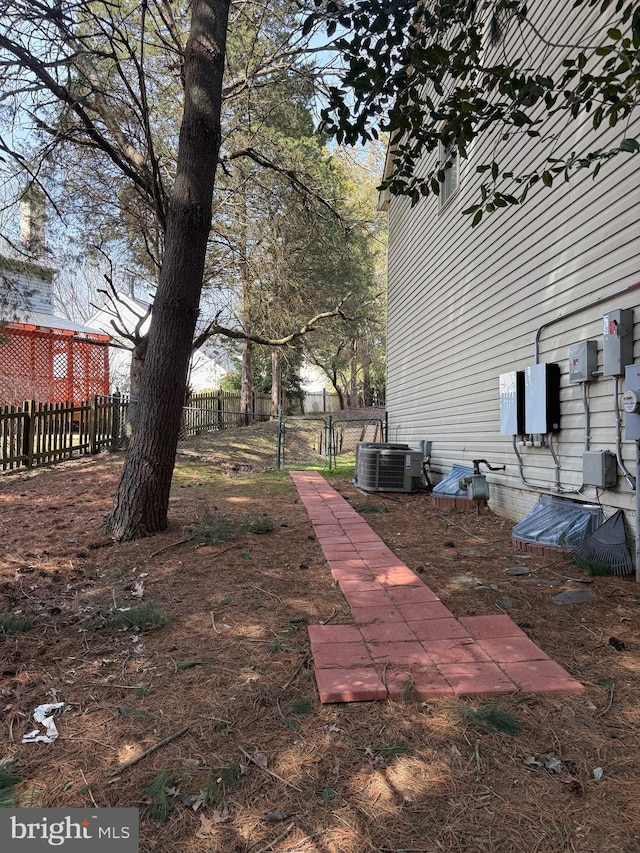 view of yard with fence and central AC