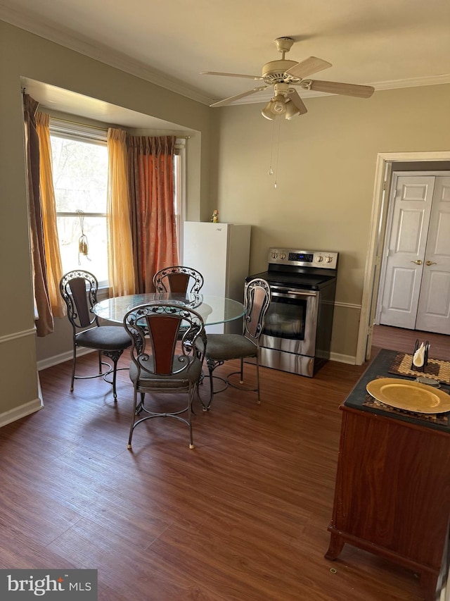 dining area with dark wood-style floors, baseboards, and ornamental molding