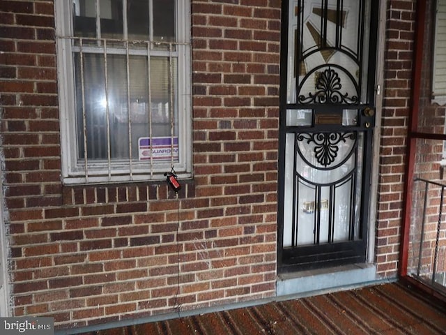 doorway to property featuring brick siding