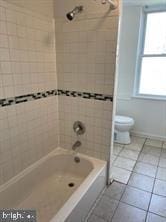 full bathroom featuring toilet, shower / tub combination, and tile patterned floors