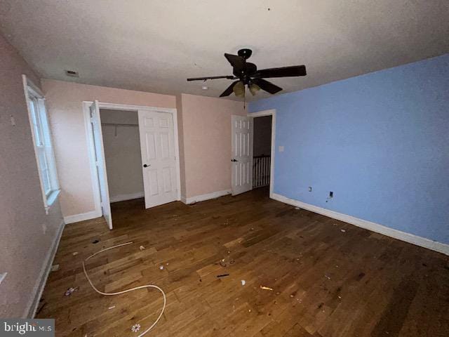 unfurnished bedroom featuring a ceiling fan, a closet, baseboards, and wood finished floors