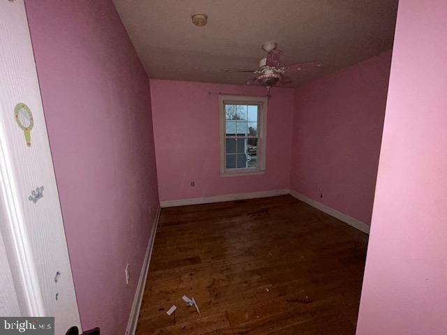 empty room featuring ceiling fan, wood finished floors, and baseboards