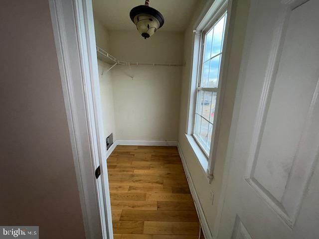 walk in closet with visible vents and wood finished floors