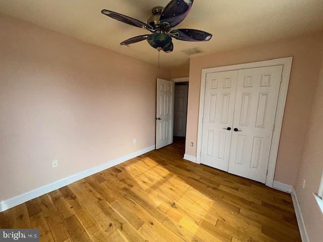 unfurnished bedroom featuring a closet, baseboards, and light wood finished floors