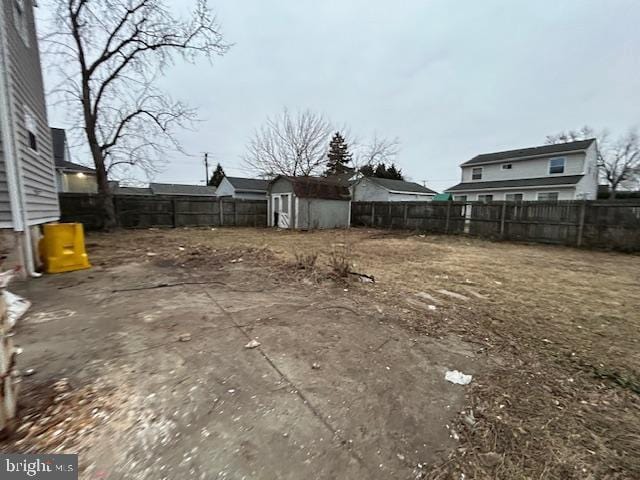 view of yard with a fenced backyard, an outdoor structure, and a shed