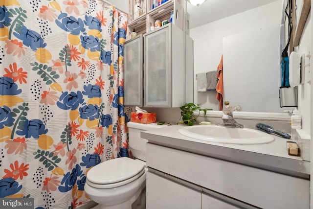 bathroom with a shower with curtain, vanity, and toilet