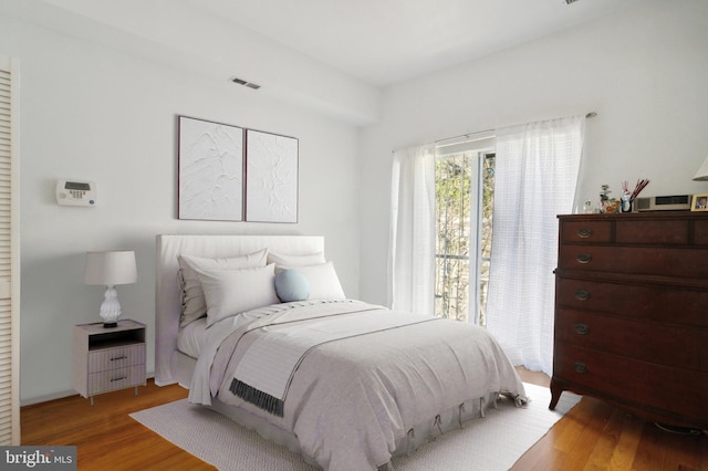 bedroom with visible vents and wood finished floors