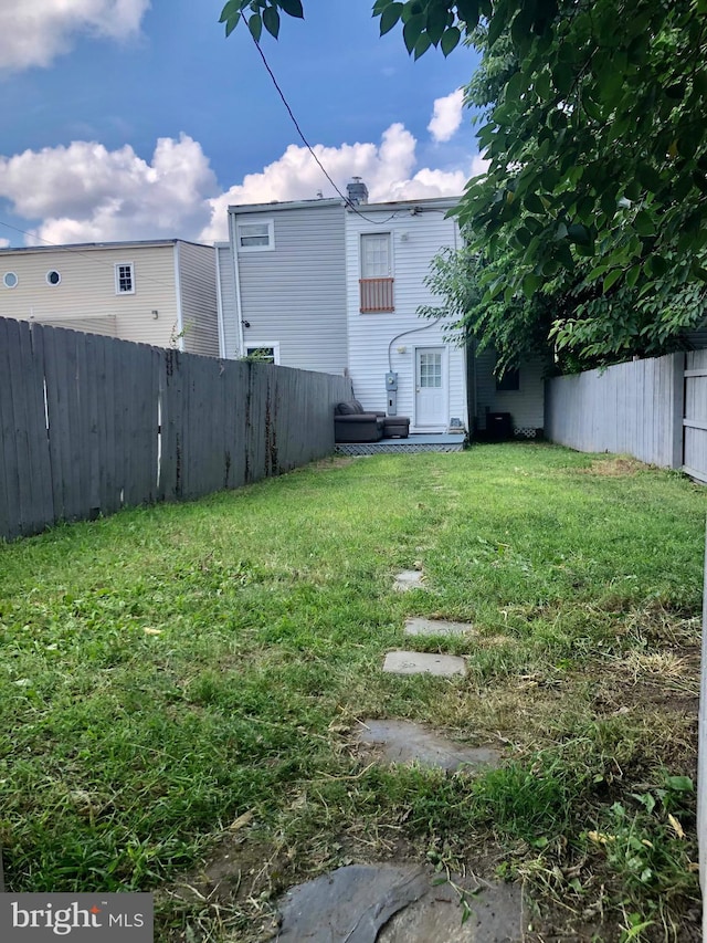 view of yard featuring entry steps and a fenced backyard