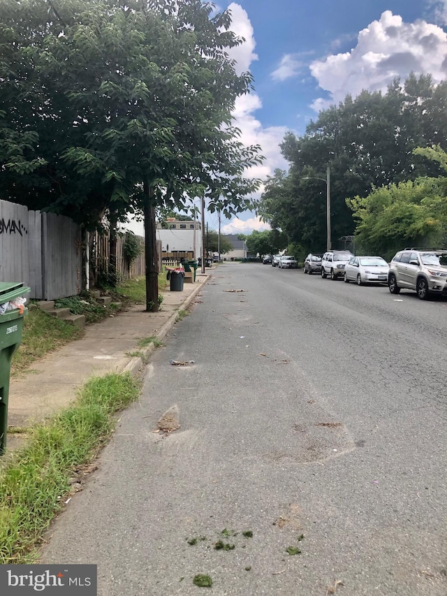 view of street featuring curbs, sidewalks, and street lights