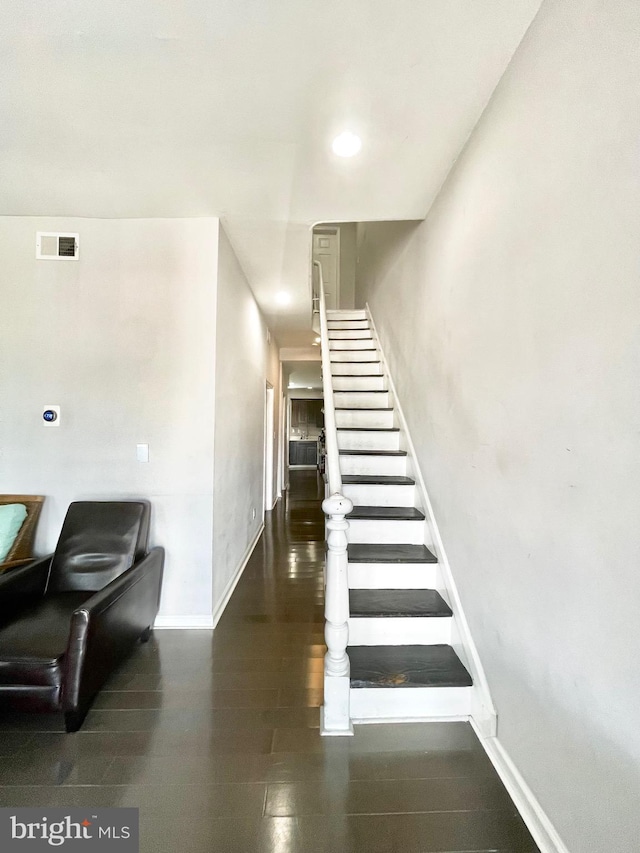 hallway featuring baseboards, stairs, and visible vents