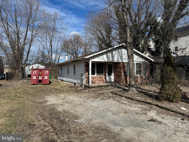 exterior space featuring brick siding and driveway