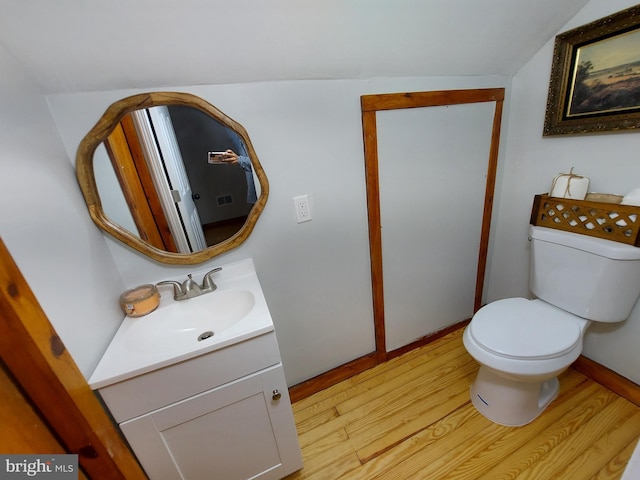 half bath with vanity, toilet, and wood finished floors