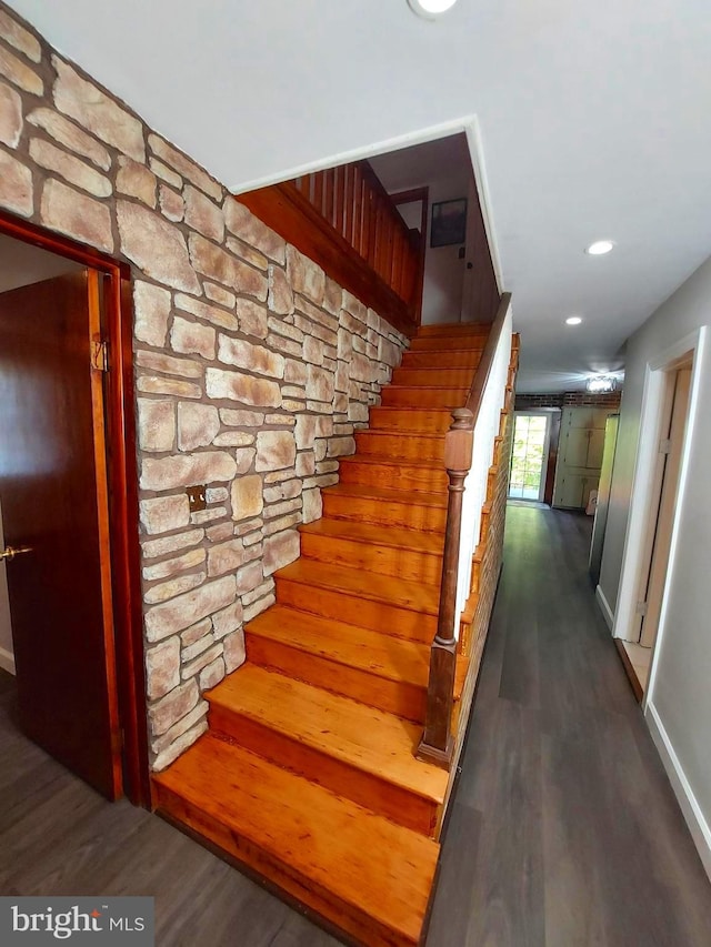 stairway with baseboards, wood finished floors, and recessed lighting