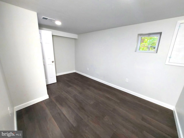 unfurnished bedroom featuring dark wood-type flooring, visible vents, and baseboards