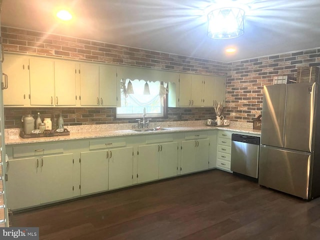 kitchen with light stone counters, stainless steel appliances, tasteful backsplash, dark wood-type flooring, and a sink