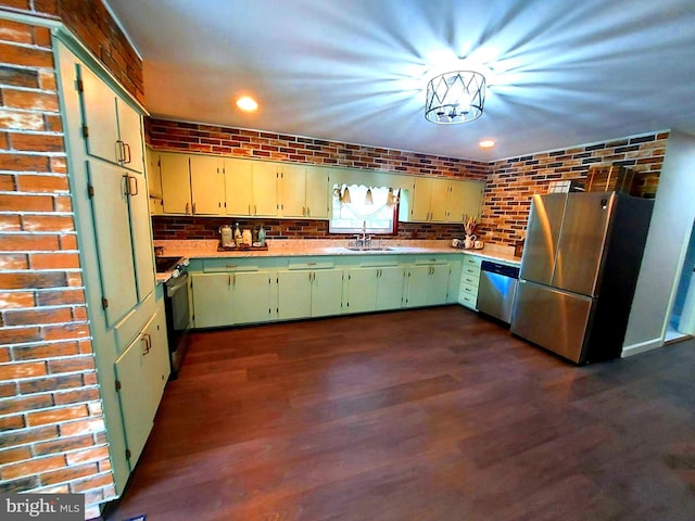 kitchen with brick wall, light countertops, a sink, and stainless steel appliances