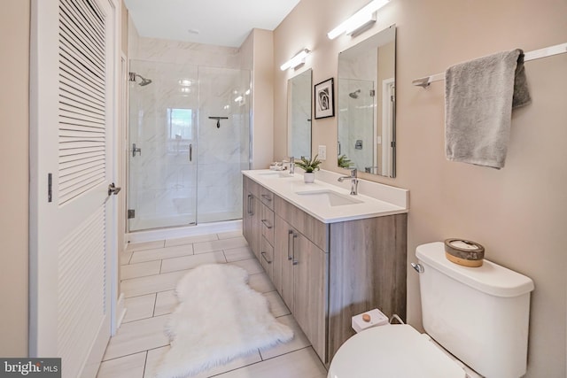 bathroom with double vanity, a stall shower, a sink, and toilet