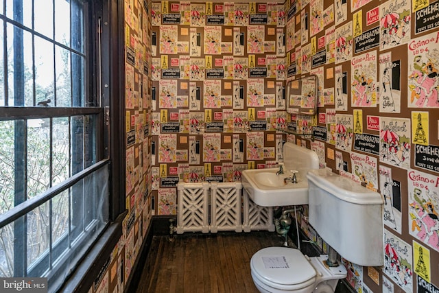 half bath featuring wood finished floors and toilet