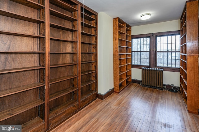 interior space featuring baseboards, hardwood / wood-style floors, and radiator