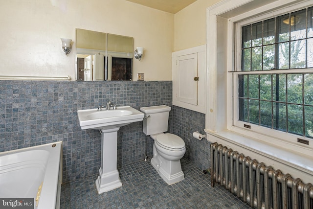 full bathroom featuring a tub to relax in, a wainscoted wall, tile walls, radiator, and toilet