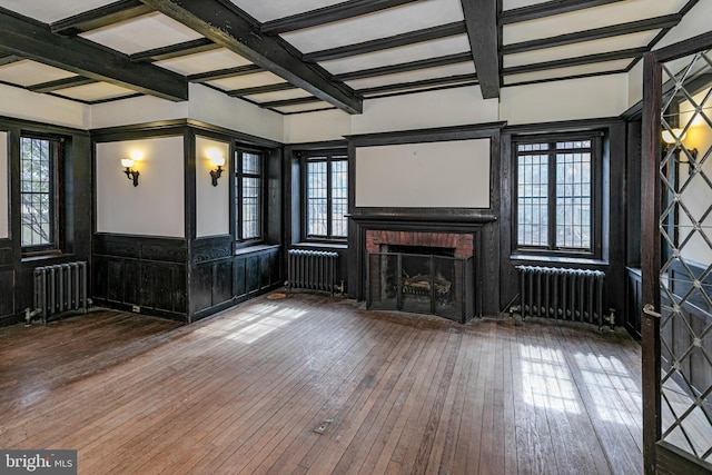 unfurnished living room with a fireplace, hardwood / wood-style flooring, and radiator