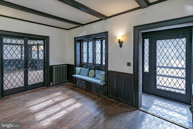 foyer featuring hardwood / wood-style flooring, a wainscoted wall, radiator heating unit, and beamed ceiling