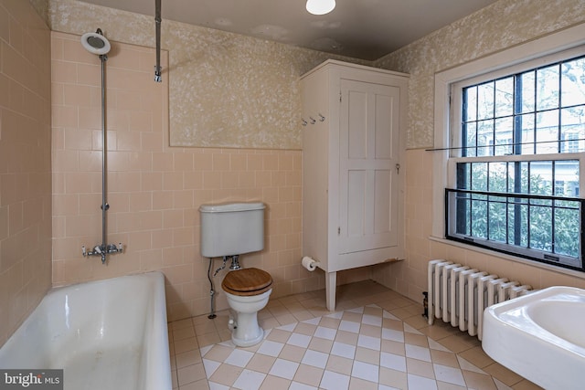 bathroom with a bathtub, tile walls, wallpapered walls, radiator heating unit, and tile patterned floors