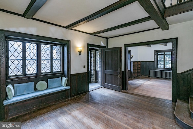 entryway with beamed ceiling, radiator heating unit, wainscoting, and wood-type flooring