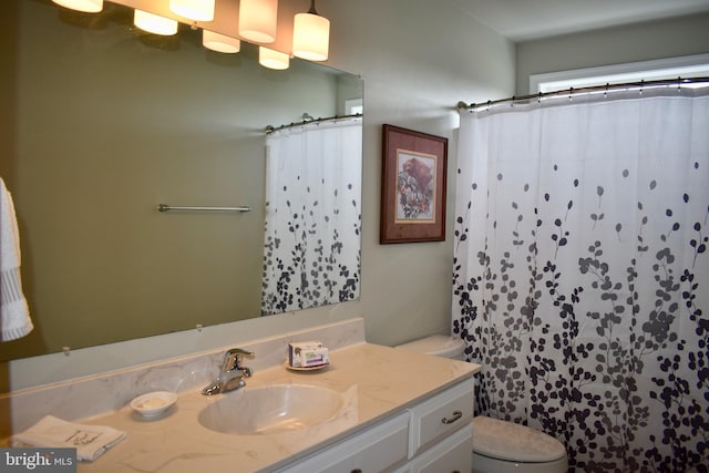 full bath with curtained shower, vanity, and toilet