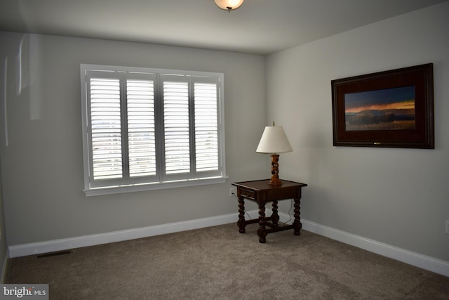 carpeted spare room with visible vents and baseboards