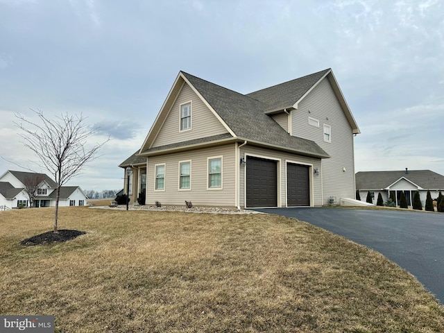 view of front of property with aphalt driveway, a front yard, a shingled roof, and a garage