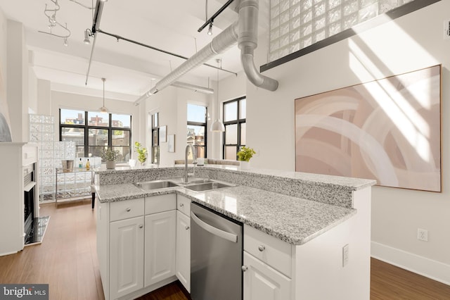 kitchen with dishwasher, light stone counters, dark wood-type flooring, white cabinetry, and a sink